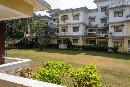 a large apartment building with a lawn in front of it at 2BHK Apartment with Pool access in Varca
