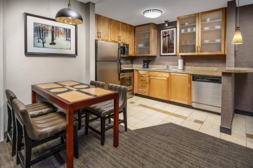 a kitchen with a table and chairs in a room at Residence Inn Burlington Colchester in Burlington