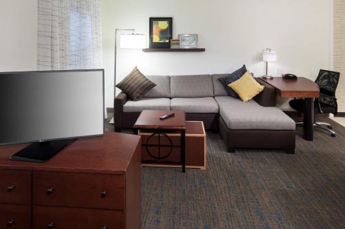 a living room with a couch and a flat screen tv at Residence Inn Boston Marlborough in Marlborough