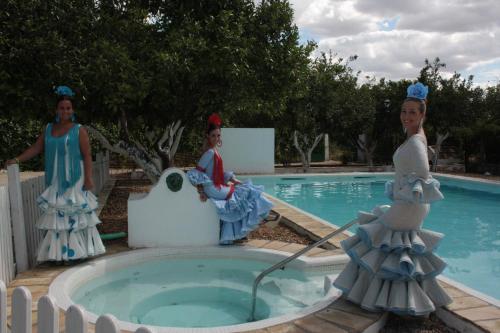 two woman statues standing next to a swimming pool at Huerta la Pimentada in Palma del Río