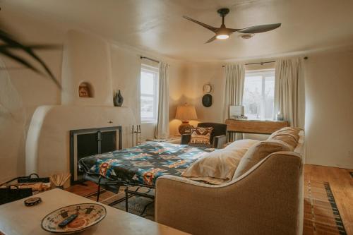 a living room with a couch and a bed at Grandma's Old Town Adobe House! Private Hot Tub-Close to Old Town-Pet Friendly-No Pet Fee! in Albuquerque