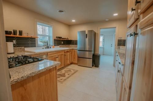 a kitchen with a stainless steel refrigerator and counters at Grandma's Old Town Adobe House! Private Hot Tub-Close to Old Town-Pet Friendly-No Pet Fee! in Albuquerque