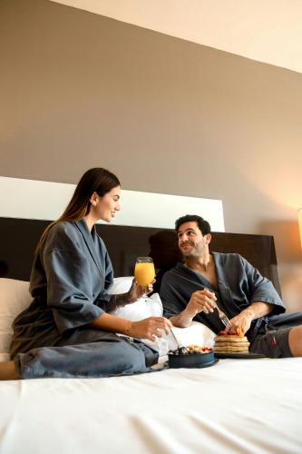 a man and a woman sitting on a bed at Marriott Panama Hotel - Albrook in Panama City