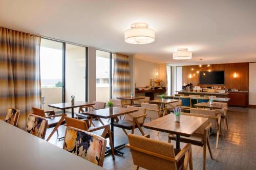 a restaurant with tables and chairs and a television at Greensboro-High Point Marriott Airport in Greensboro