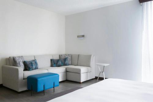 a living room with a couch and a blue stool at Greensboro-High Point Marriott Airport in Greensboro