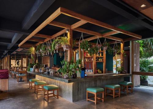 a restaurant with a bar with green stools at Shore Amora Canggu in Canggu