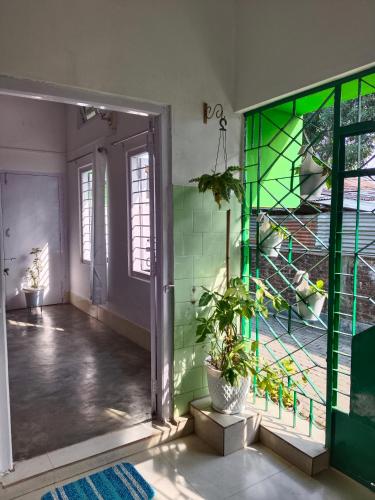 a room with a green glass door with plants in it at HURGEN Stay in Kāziranga
