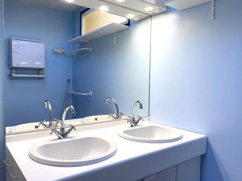 une salle de bain avec deux lavabos et un miroir dans l'établissement Maison à 350m plage avec jardin sud et WIFI à Trégastel - FR-1-368-437, à Trégastel