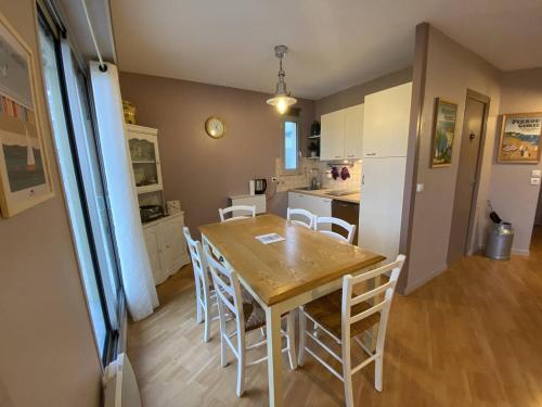 une cuisine et une salle à manger avec une table et des chaises en bois dans l'établissement Appartement rénové à 20m de la plage Trestraou, 2 ch, court séjour possible, animal accepté - FR-1-368-444, à Perros-Guirec