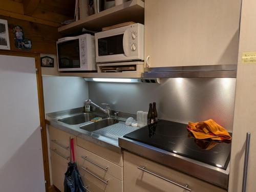 Il comprend une petite cuisine équipée d'un évier et d'un four micro-ondes. dans l'établissement Charmant appartement 3 pièces à La Clusaz avec terrasse et WIFI - FR-1-459-237, à La Clusaz