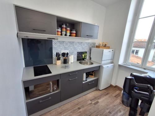 La cuisine est équipée d'un comptoir avec évier et d'un réfrigérateur. dans l'établissement Appartement lumineux 2 ch, proche plage & commerces - FR-1-706-31, à Châtelaillon-Plage