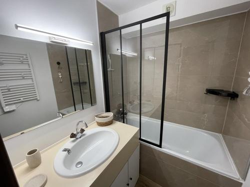 une salle de bain avec un lavabo, une douche et une baignoire dans l'établissement Studio en station, au pied des pistes, balcon Sud-Est - FR-1-787-110, à Laveissière