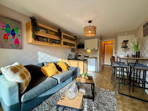 un salon avec un canapé bleu et une cuisine dans l'établissement Studio lumineux à Carnac, proche plage, parking privé, animaux admis - FR-1-377-95, à Carnac