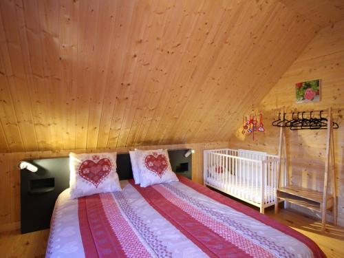 a large bed in a room with a wooden ceiling at Chalet au Mont-Dore, 8 pers, 3 ch, animaux admis, parking, terrasse, proche centre - FR-1-608-281 in Mont-Dore
