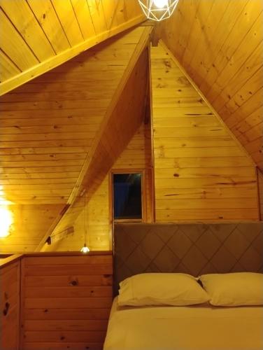 a bedroom in a log cabin with a bed at Cabanas Pôr do Sol - São Chico in São Francisco de Paula