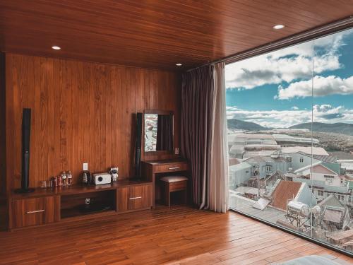 a room with a desk and a large window at Lux Nest hotel in Ấp Kim Thạch