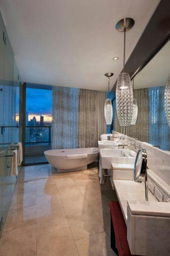 a bathroom with three sinks and a bath tub at JW Marriott Panama in Panama City
