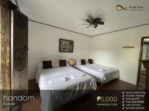 a bedroom with two beds and a ceiling fan at Panaad Garden in Tagaytay