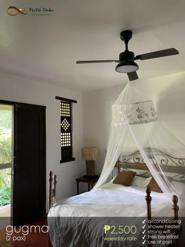 a bedroom with a bed with a ceiling fan at Panaad Garden in Tagaytay