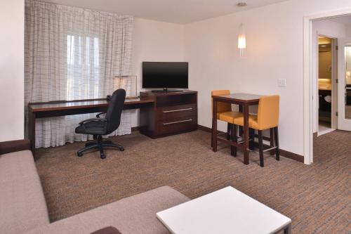 a room with a desk with a computer and a chair at Residence Inn by Marriott Cedar Rapids South in Cedar Rapids