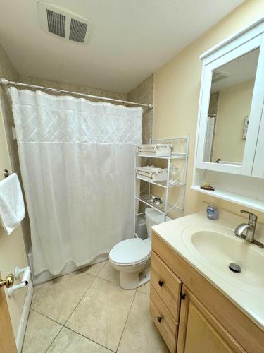 a bathroom with a toilet and a sink at Sunset Villa Pool & Spa Near The Beach in Naples