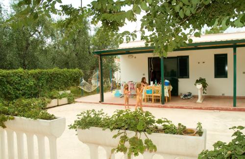 un jardín con una casa con mesa y sillas en Mattinata Camping, en Mattinata