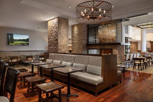 a restaurant with a couch and tables and chairs at Marriott Riverside at the Convention Center in Riverside
