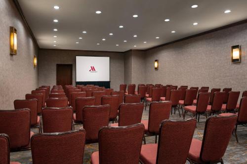 a conference room with red chairs and a screen at Marriott Riverside at the Convention Center in Riverside