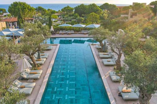 an overhead view of a swimming pool with chairs and umbrellas at The Romanos, a Luxury Collection Resort, Costa Navarino in Romanós