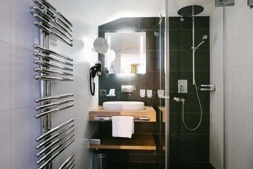 a bathroom with a sink and a shower at Hotel & Restaurant Zum Schwarzen Bären in Andermatt