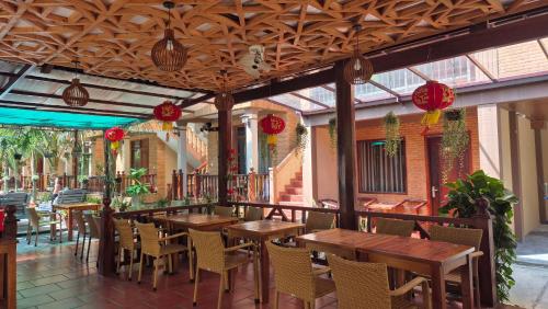 an outdoor restaurant with wooden tables and chairs at Valentina Resort & Spa Phu Quoc in Phu Quoc