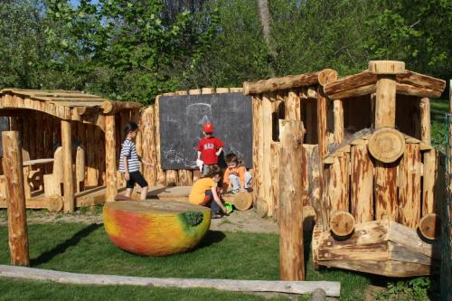 a group of children playing in a wooden playground at Penzion U Černého Potoka in Nová Lhota