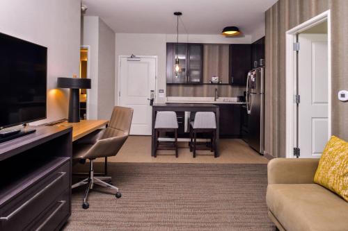 a kitchen and living room with a table and chairs at Residence Inn by Marriott Charlotte Steele Creek in Charlotte