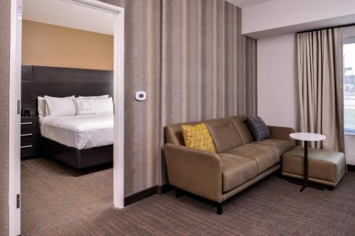 a hotel room with a couch and a bed at Residence Inn by Marriott Charlotte Steele Creek in Charlotte