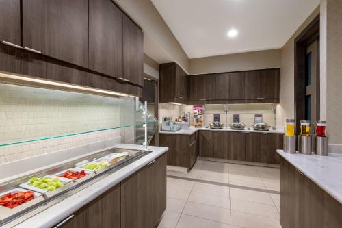 a large kitchen with wooden cabinets and food on display at Residence Inn by Marriott Charlotte City Center in Charlotte