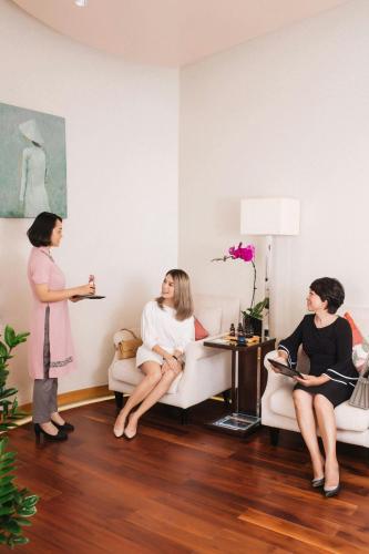 three women sitting in chairs in a living room at JW Marriott Hotel Hanoi in Hanoi