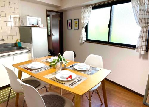 a dining room table with white chairs in a kitchen at HARUKAZE HOUSE in Tokyo
