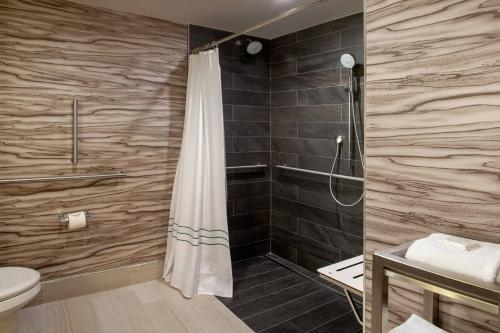 a bathroom with a shower with a shower curtain at Marriott Raleigh Durham Research Triangle Park in Durham