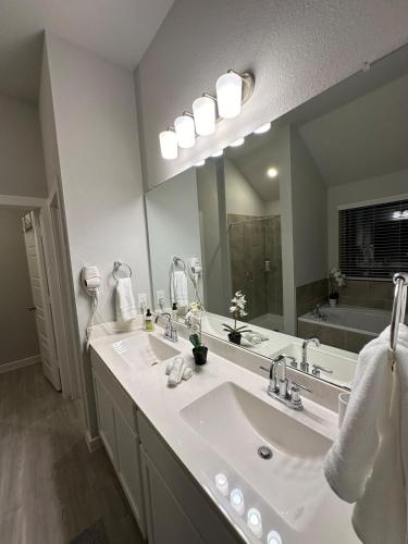a bathroom with two sinks and a large mirror at Beautiful spacious house with great location! in Conroe