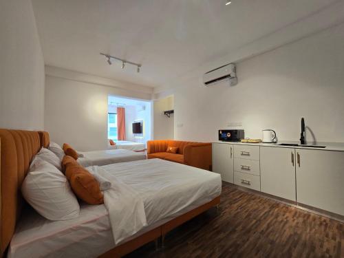 a bedroom with a bed and an orange chair in it at K Avenue Sunset View Condomonium - Kota Kinabalu Airport in Kota Kinabalu