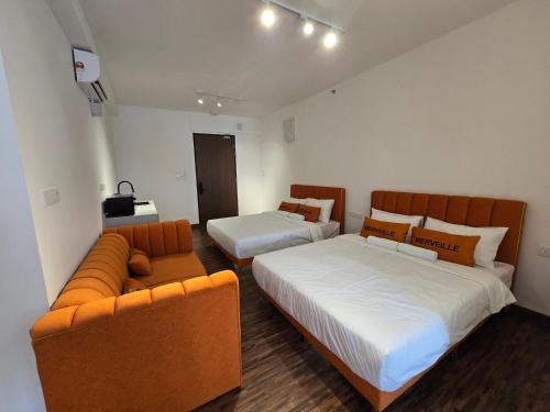 a hotel room with two beds and a couch at K Avenue Sunset View Condomonium - Kota Kinabalu Airport in Kota Kinabalu