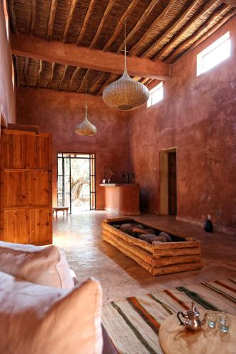 a living room with a large couch in the middle of the room at La Ferme Berbere Adult only in El Harkat