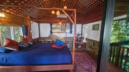 a bedroom with a blue bed in a house at Mai Pen Rai Bungalows in Than Sadet Beach