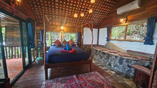 a bedroom with a bed and a fireplace in a house at Mai Pen Rai Bungalows in Than Sadet Beach