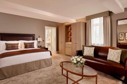 a hotel room with a bed and a couch at The Langley, a Luxury Collection Hotel, Buckinghamshire in Iver