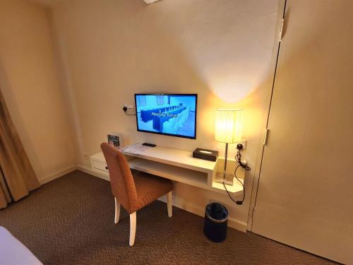 a room with a desk with a monitor and a chair at The Grand Puteri Hotel in Kuala Terengganu