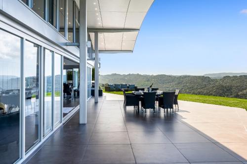 a patio with a table and chairs on a building at Luxury Hilltop Villa with Breathtaking Views- Perfect for Family Stays & Events in Waiwera