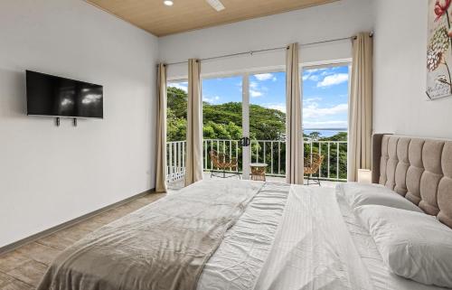 a bedroom with a large bed and a large window at Casa amor del sol apartment # 3 in Tarcoles