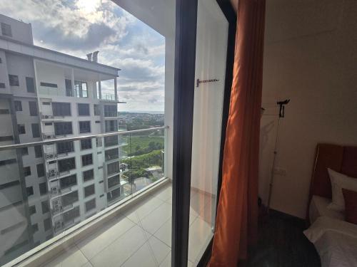 a room with a balcony with a view of a building at K Avenue Sunset View Condomonium - Kota Kinabalu Airport in Kota Kinabalu