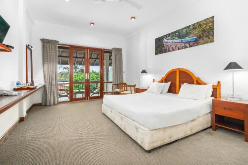 ベントータにあるHotel Nilwalaの大きな白いベッドと机のある寝室